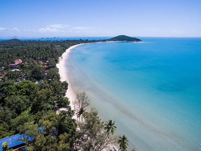 Aerial view of the Lipa Noi coastline on Koh Samui, turquoise sea and palm trees.
