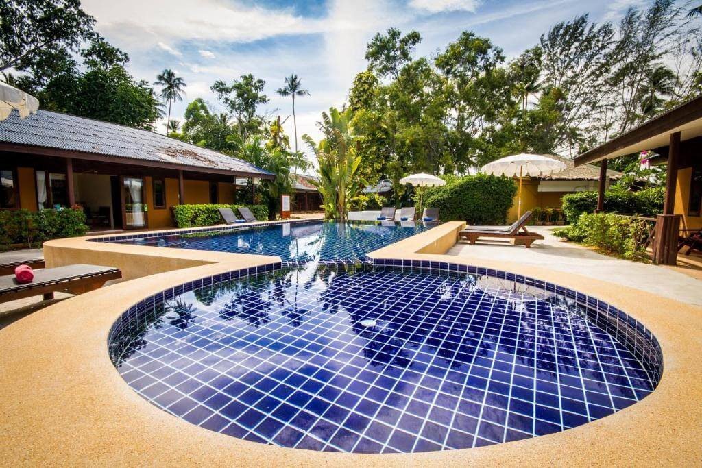 Blue-tiled swimming pool beside the accommodation, surrounded by palm trees