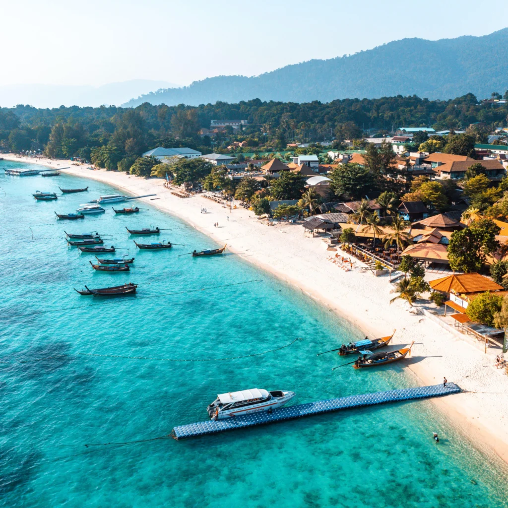 Aerial view of a Thai beach with longtail boats moored offshore