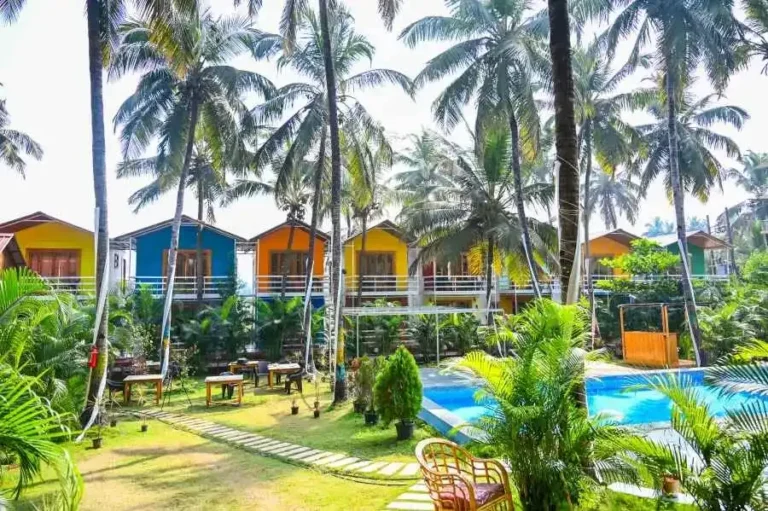 Colourful cottages and pool among palms in Goa