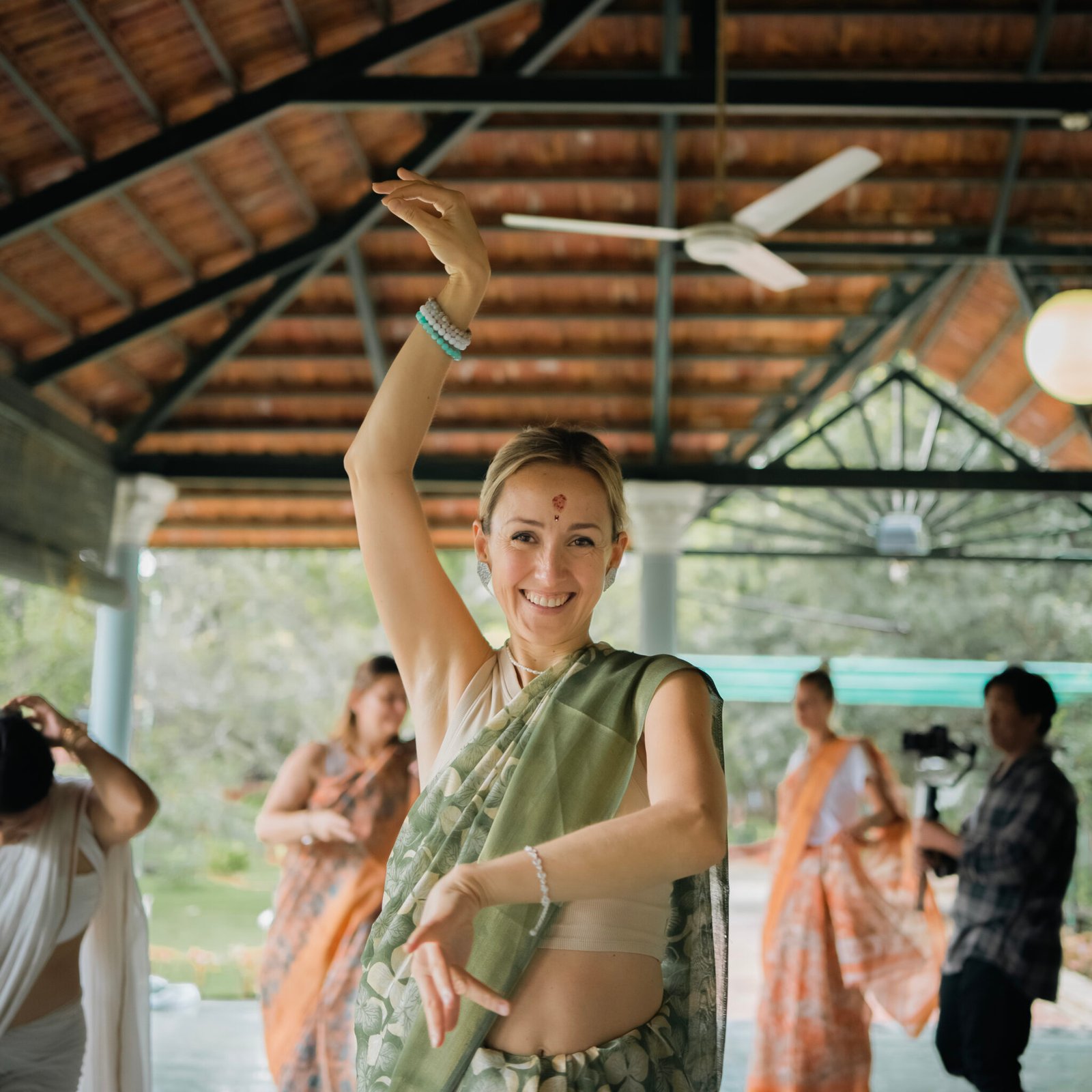 Student in a green sari dancing during a cultural evening at the yoga shala